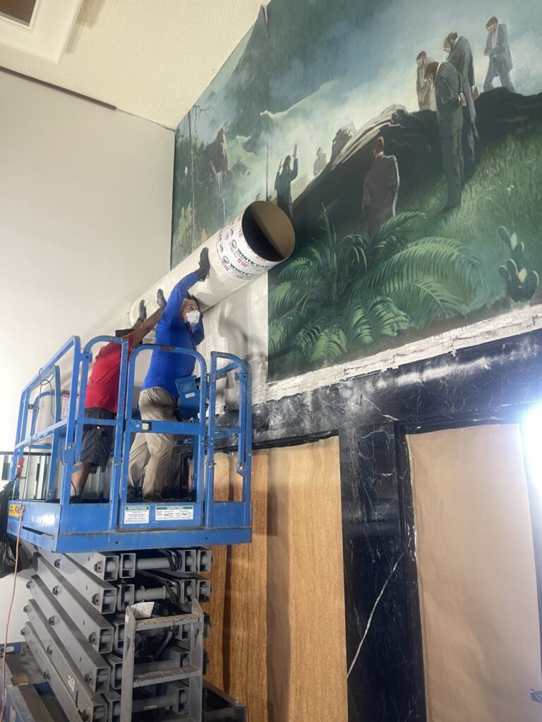 FACL mural team preparing the mural to be transported on large tubes 